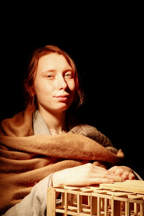 A woman in a blanket holding a wooden box