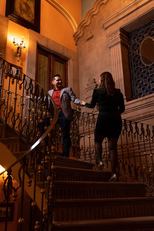 Well-dressed Couple Walk Up Stairs in Palace