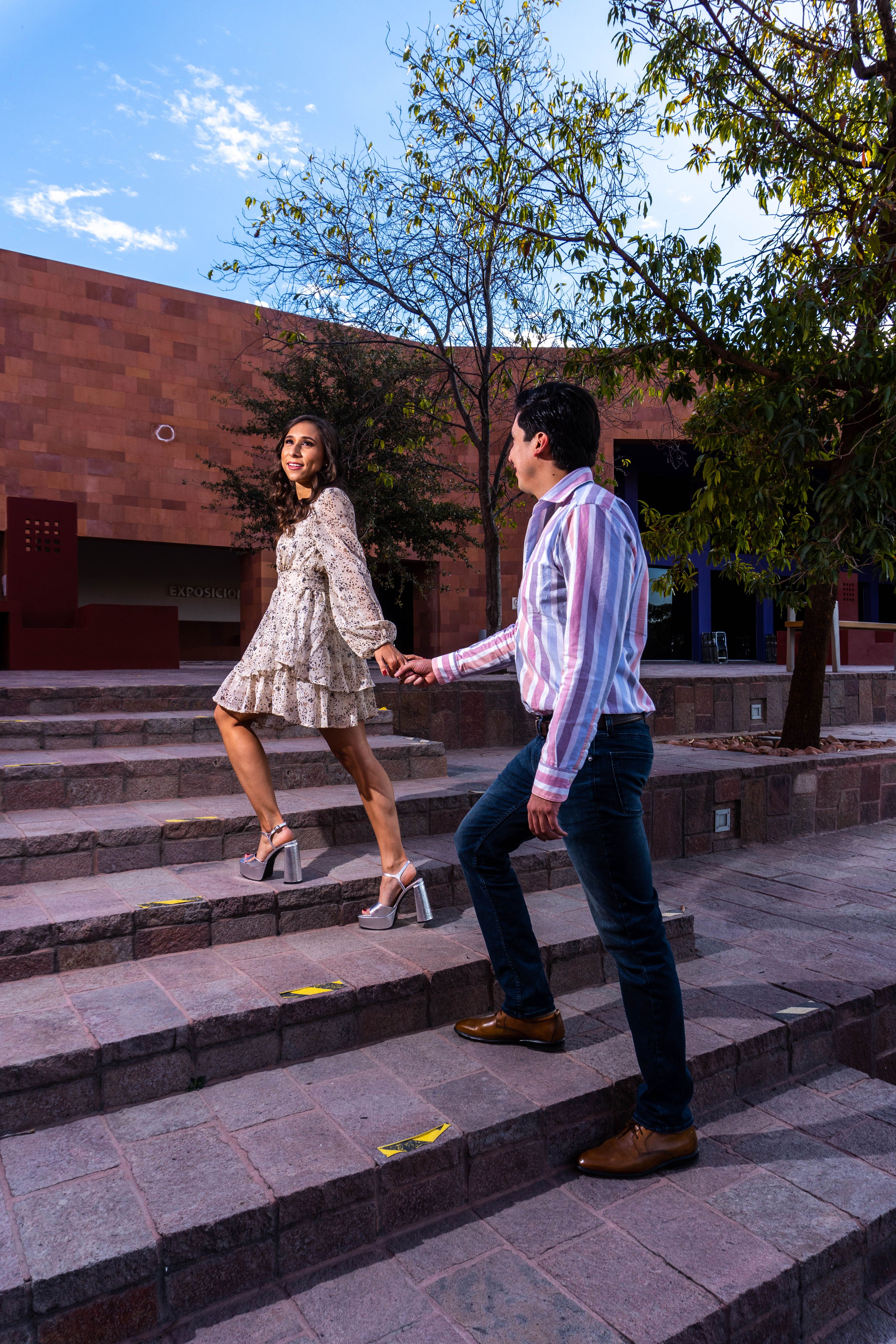 A couple is walking down some steps in front of a building · Free Stock ...