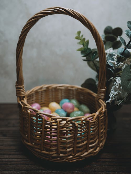 A basket with eggs and flowers on a table