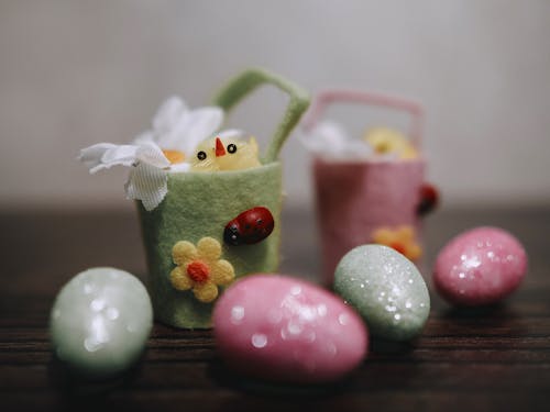 Easter eggs and flowers in baskets on wooden table