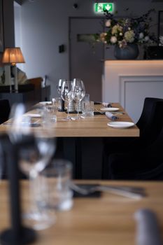 Atmospheric dining area with wooden tables, glassware, and floral decor.