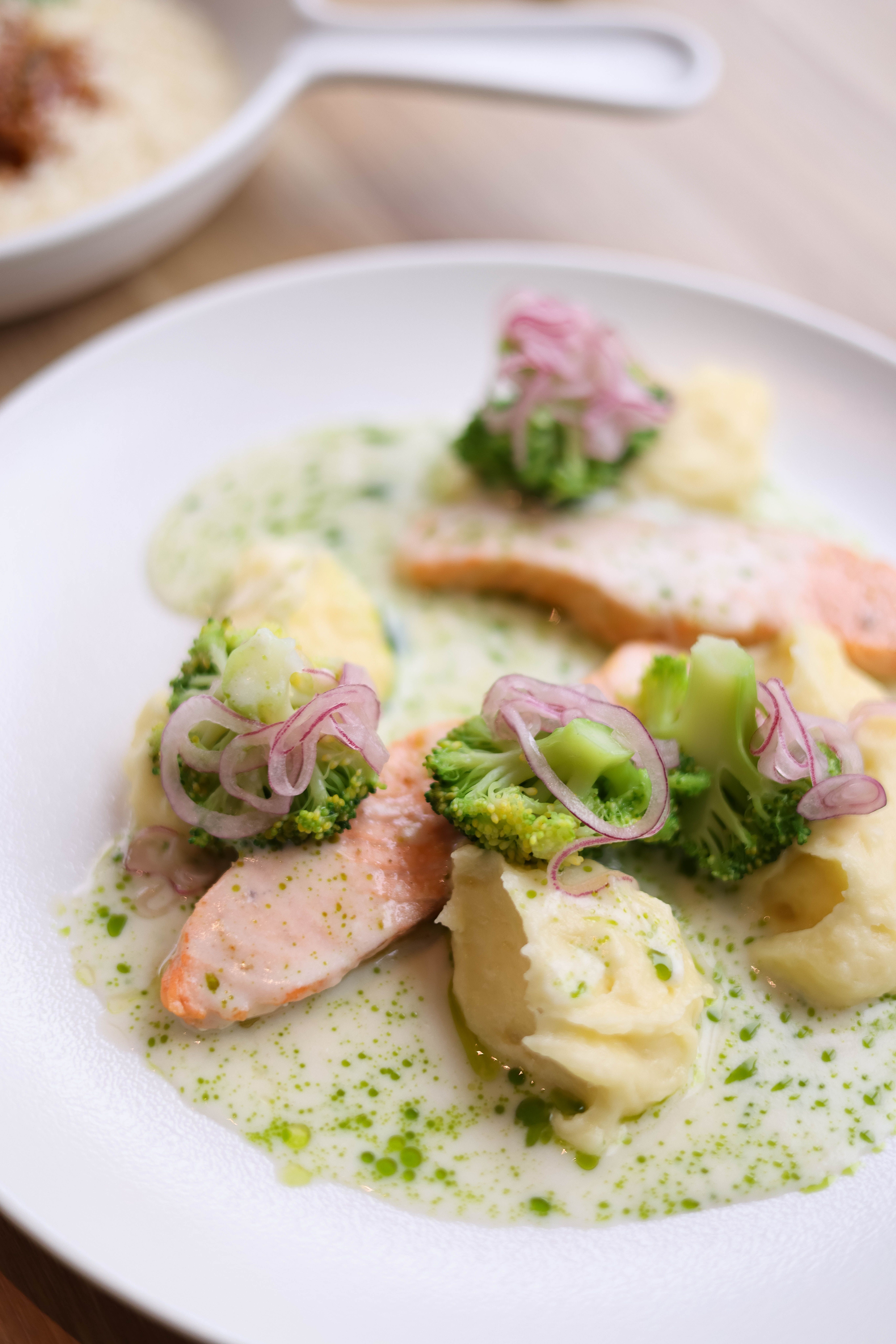Gourmet salmon with broccoli and creamy puree on a stylish plate, perfect for fine dining imagery.
