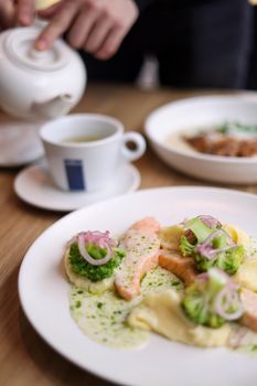 A delectable salmon meal served with a cup of tea, highlighting fresh ingredients.