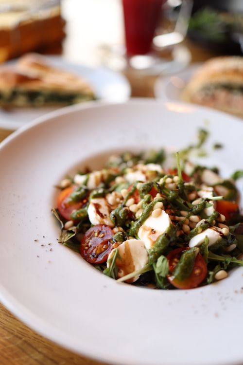 Free Delicious Caprese salad topped with pine nuts and fresh pesto, perfect for a refreshing meal. Stock Photo