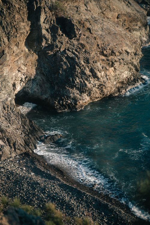 Free High angle view of rugged cliffs with waves crashing on the shoreline. Stock Photo
