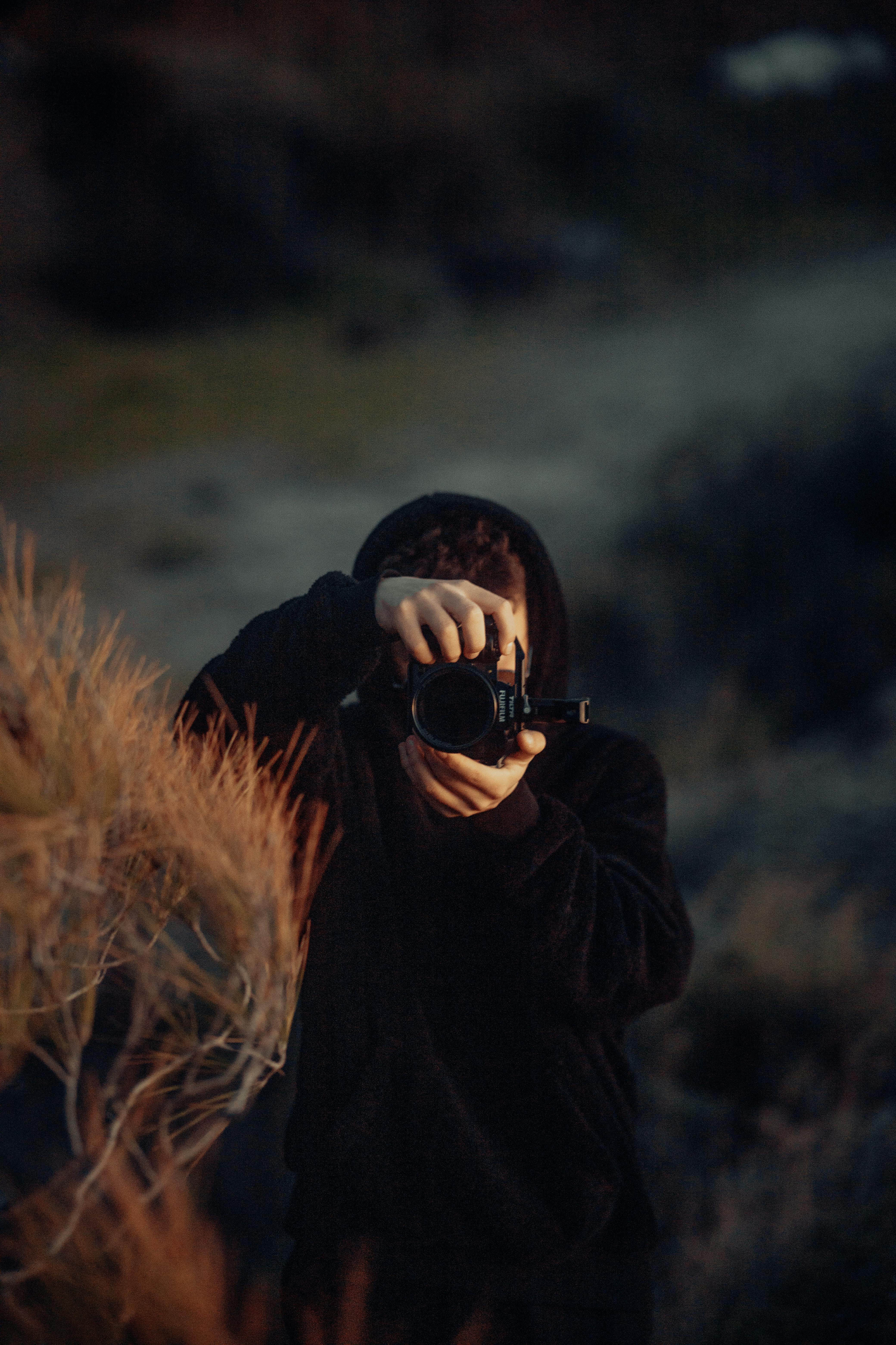 man in black hoodie taking pictures with camera