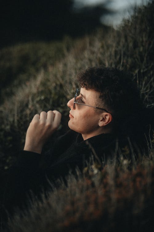 A man in sunglasses sitting in the grass