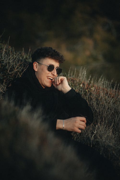 Smiling Man in Sunglasses Sitting in Grass