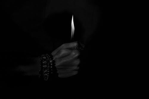 A person holding a lit candle in the dark