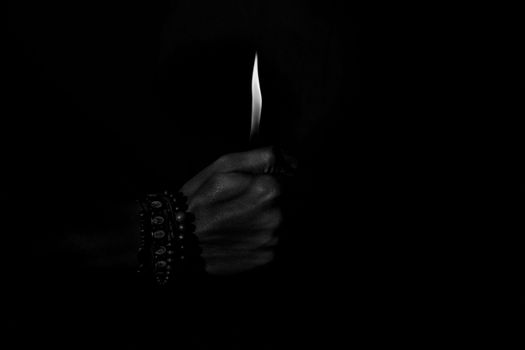 Lighter Flame in Hand in Darkness