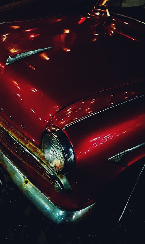 A Red Vintage Car with a Rusty Bumper 