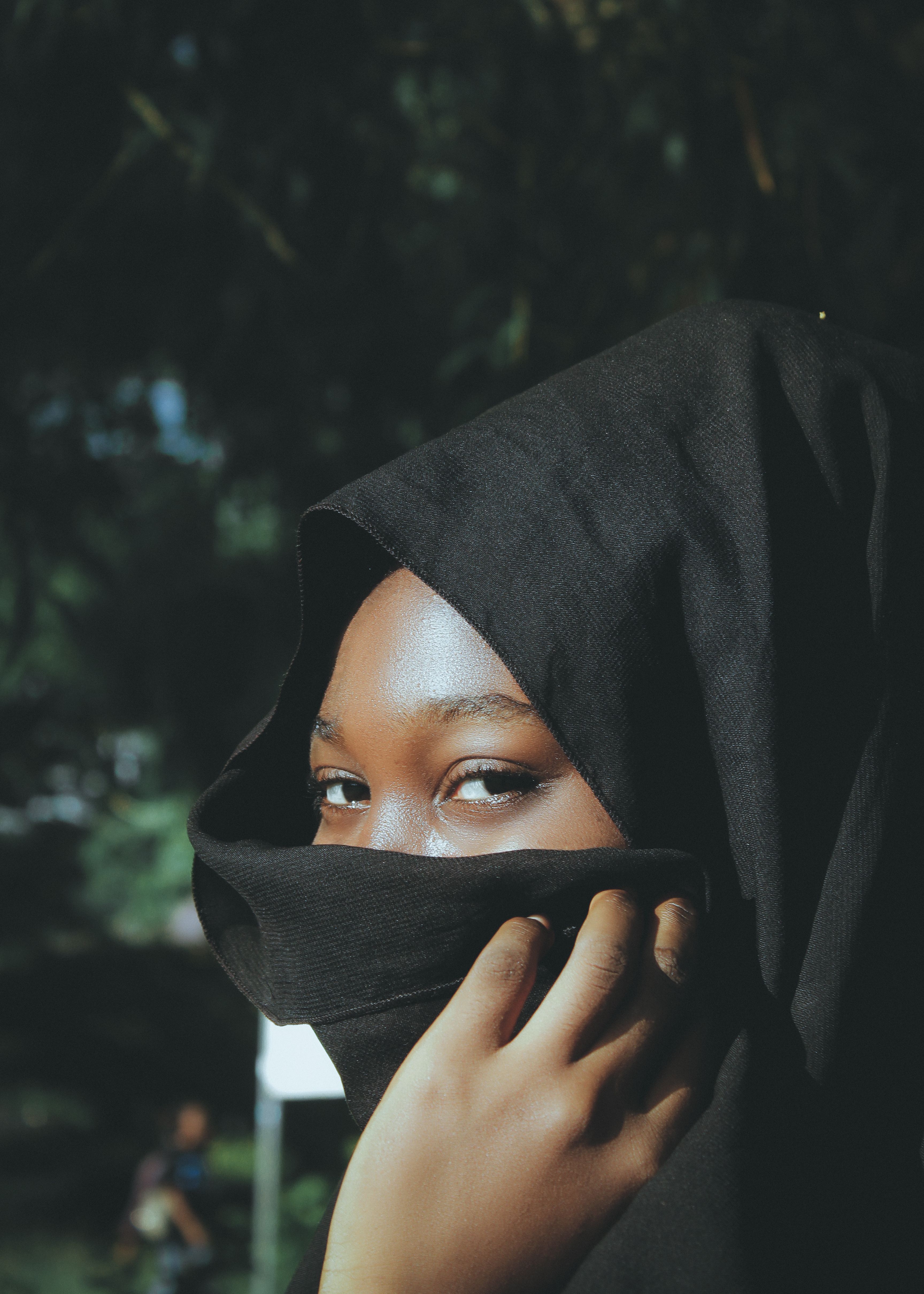Young Woman Standing Outside Covering Her Face with a Black Headscarf ...