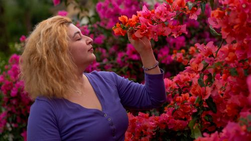 Free A woman enjoys the vibrant blooms of bougainvillea in Ciudad de México, capturing a serene moment of nature. Stock Photo