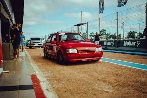 A red car is parked on the track