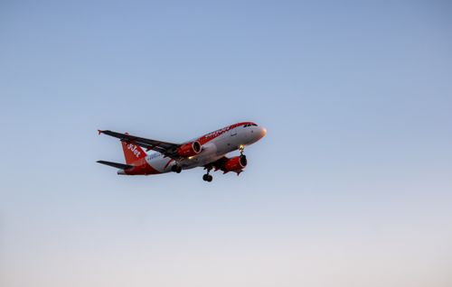 Free A commercial airplane descends for landing against a clear evening sky. Stock Photo