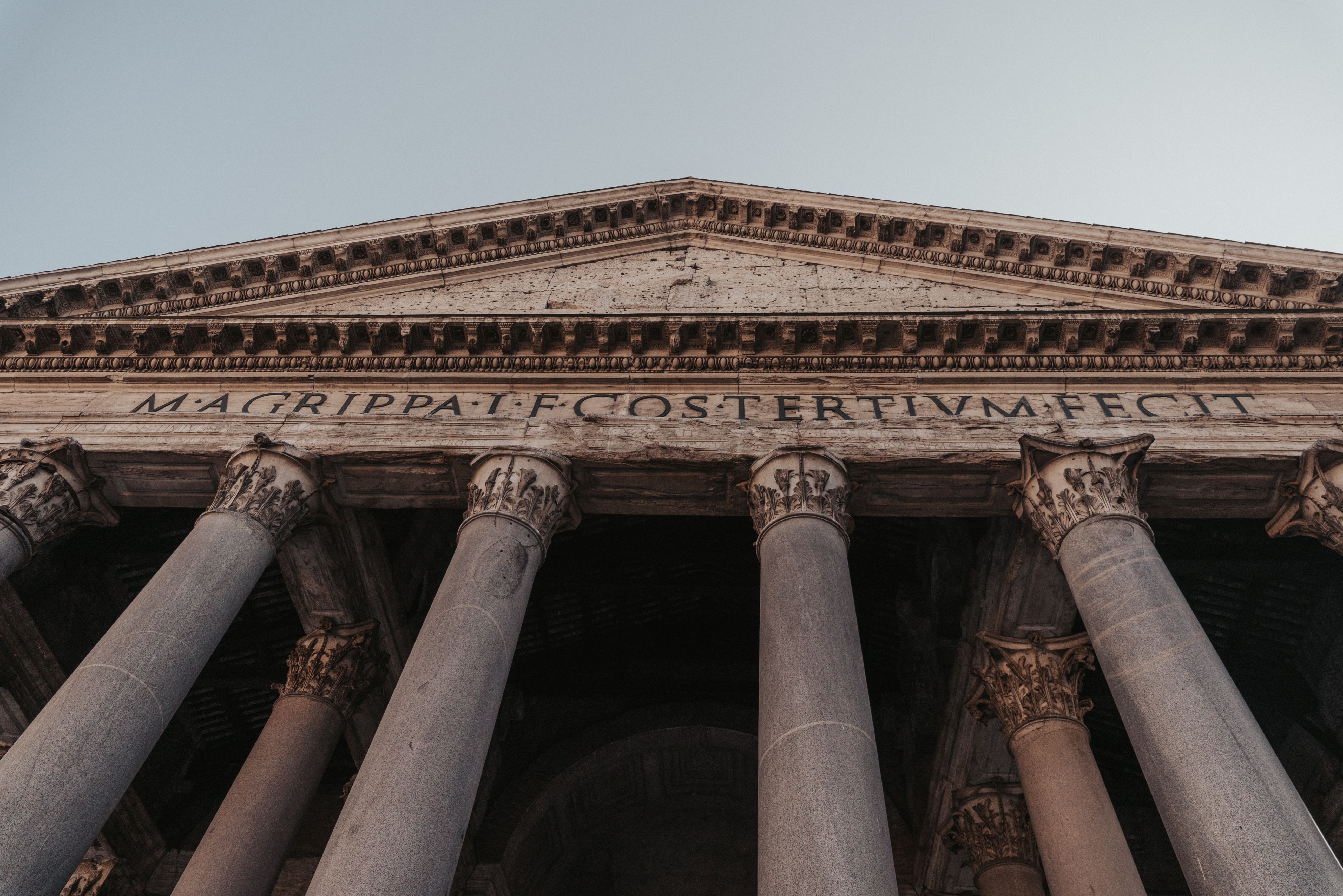 A low angle view of the Pantheon in Rome, showcasing its iconic columns and ancient architecture.