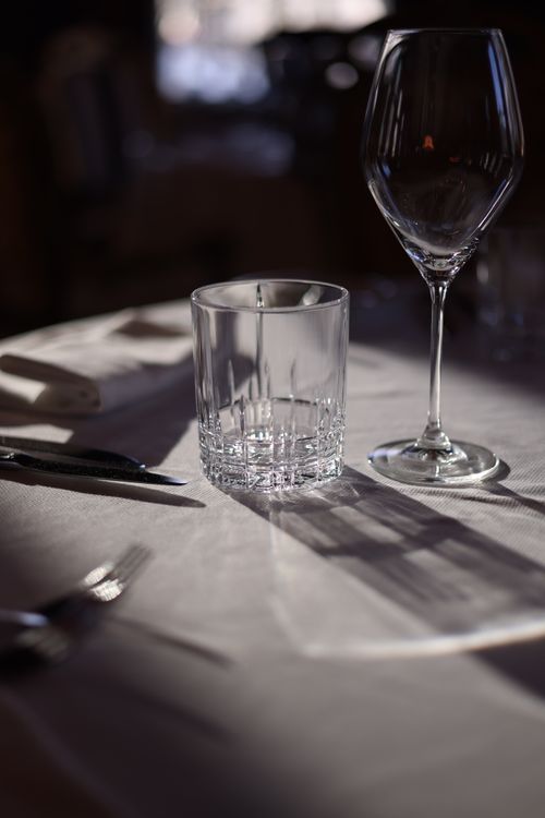Free Close-up of elegant table setup in a restaurant featuring glassware and tableware under ambient light. Stock Photo