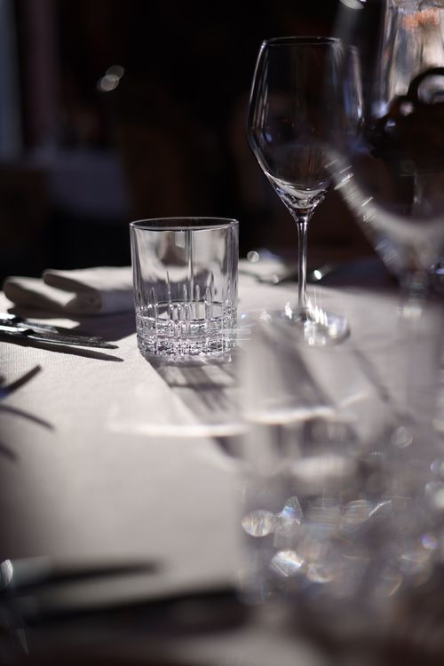Free Elegant dining table with wine glasses and sunlit ambiance in a restaurant. Stock Photo
