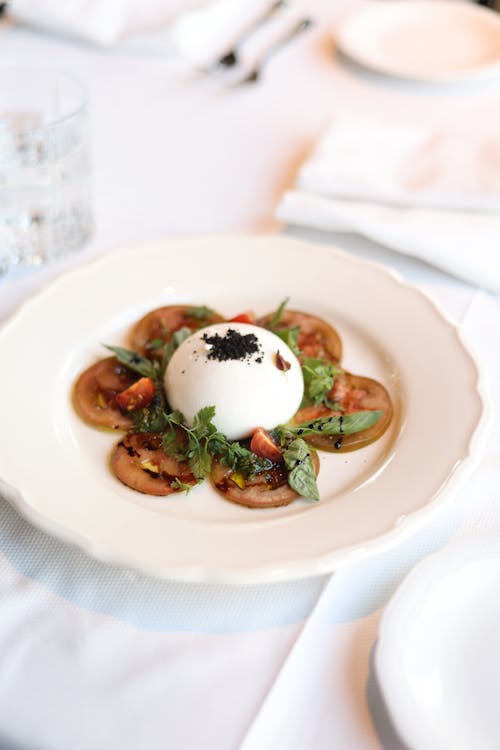 A white plate with a small dish of food on it