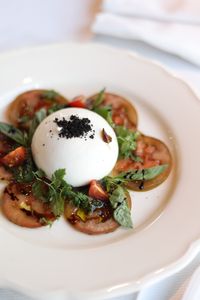 Fresh burrata cheese with herbs — photo by Valeria Boltneva on Pexels