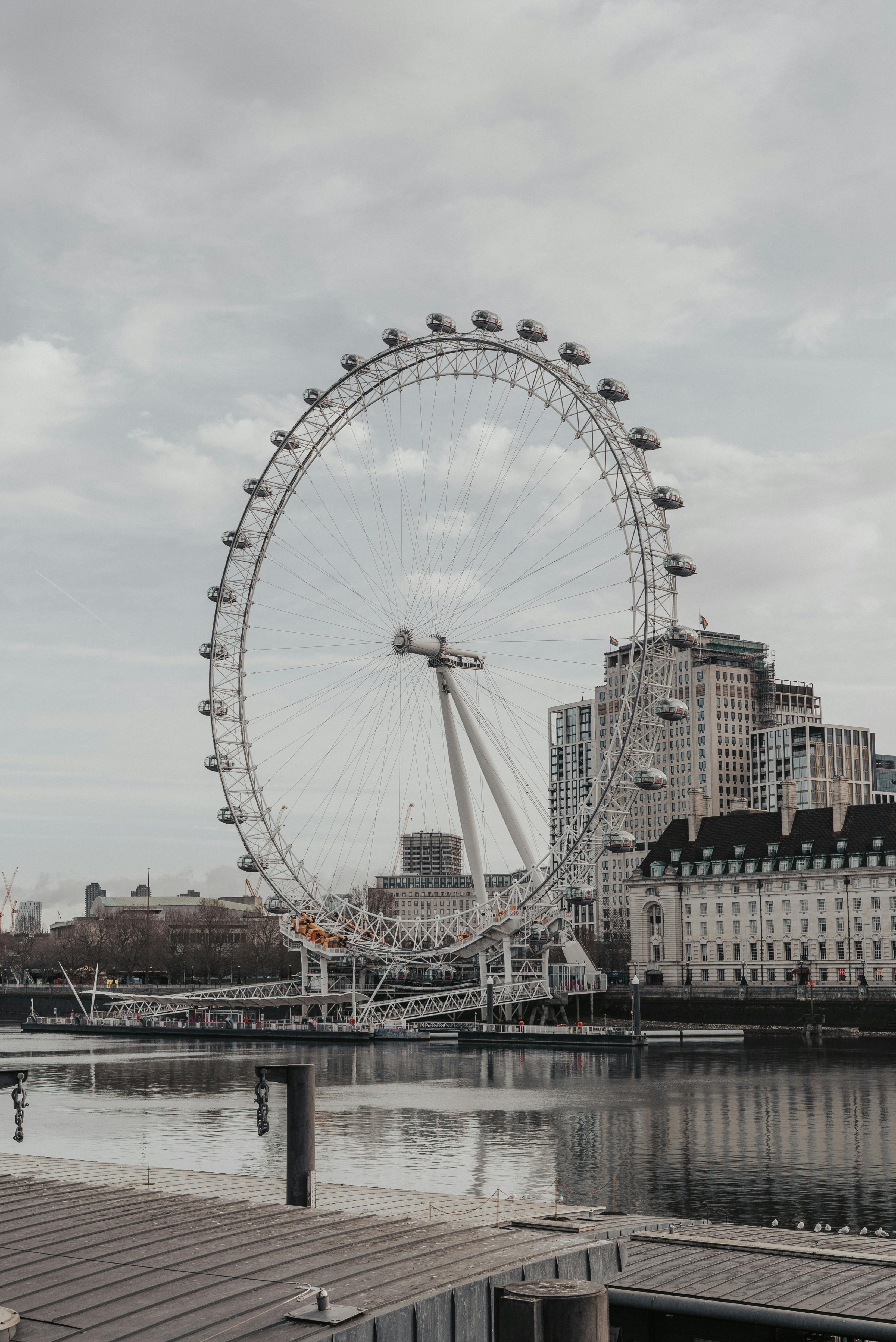 The iconic London Eye and city skyline reflecting on the River Thames, a symbol of modern London.