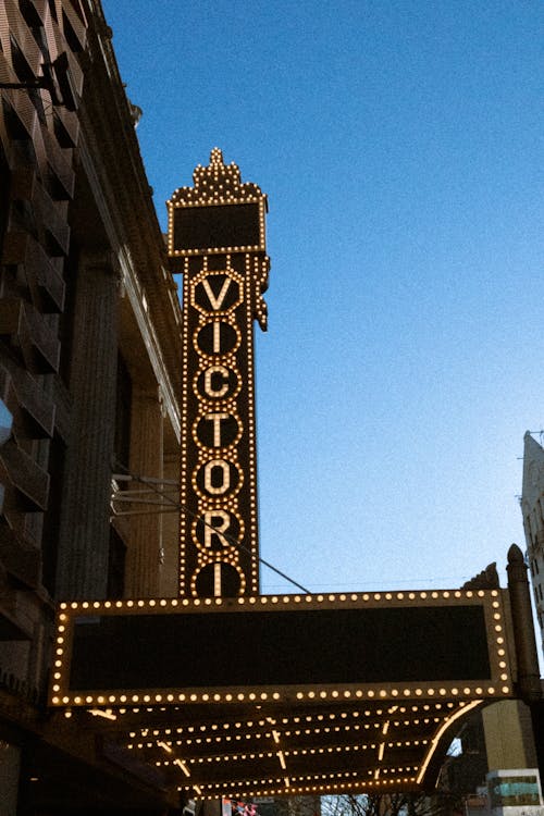 A sign for the theater is lit up at night