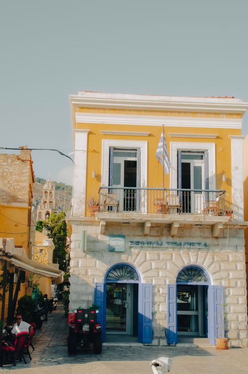 Free A picturesque yellow building with balconies in Symi, Greece, under a clear blue sky. Stock Photo