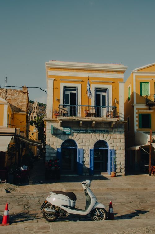Free Charming view of Greek architecture in Symi with a scooter parked outside, perfect for travel enthusiasts. Stock Photo