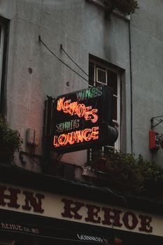 Neon sign with 'Kehoes Lounge' on an urban pub facade, displaying a classic and vibrant vibe.
