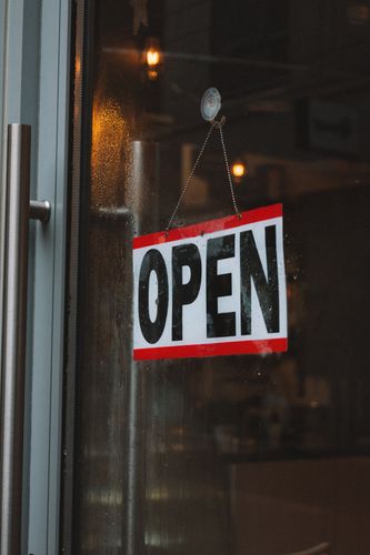 A cafe entrance with an open sign on the glass door