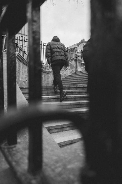 Person in Jacket on Stairs on Street
