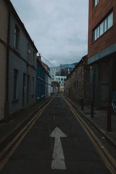 A narrow, moody alleyway lined with old buildings in a city setting.