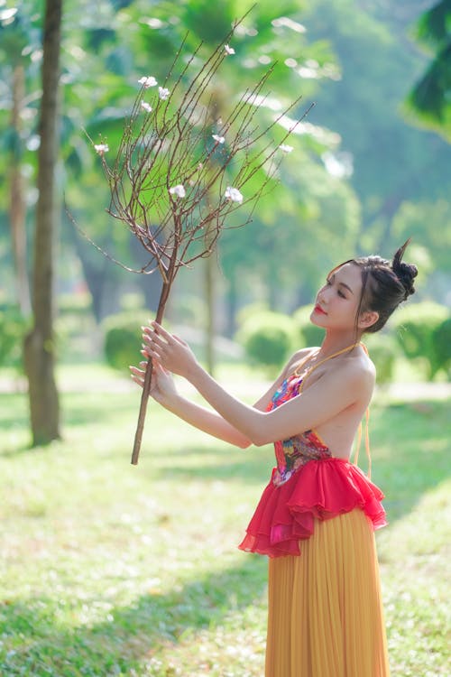 Young Woman in an Elegant Dress Posing in a Park 