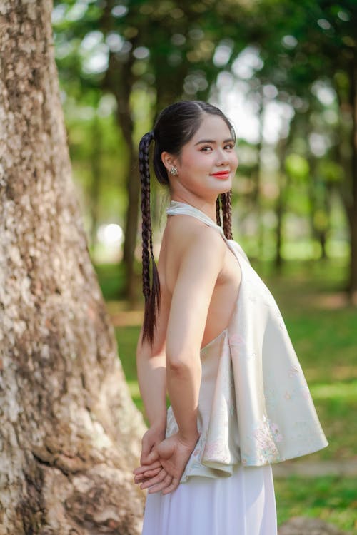 Pretty Brunette Woman in White Blouse Posing by Tree