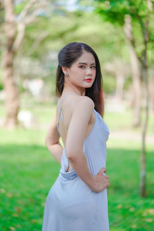 Young Woman in an Elegant Dress Posing in a Park 