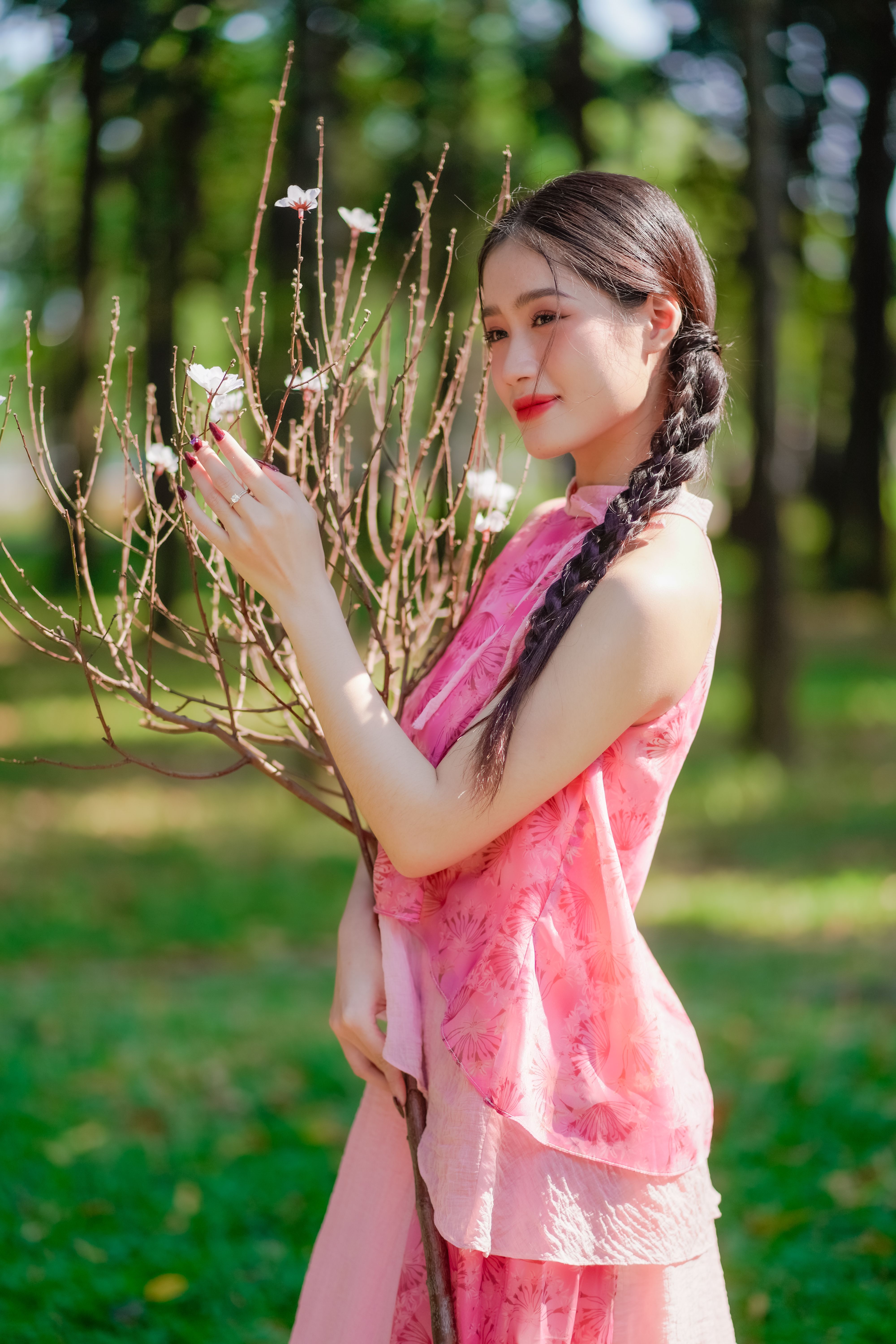 A woman in pink dress holding a branch of flowers · Free Stock Photo