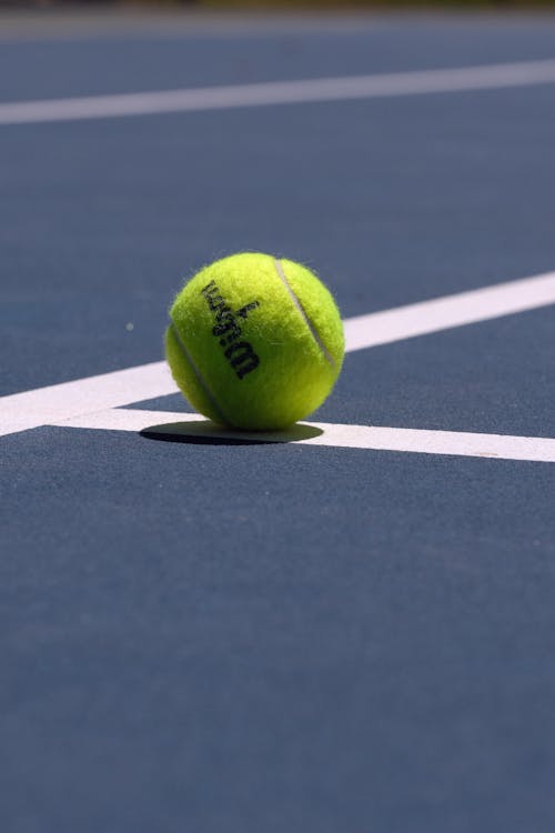Close-up of a Tennis Ball Lying on a Tennis Court 