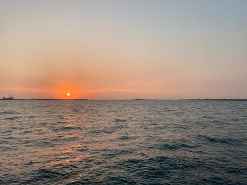 Sunset over a Sea with View of Harbor in the Horizon 
