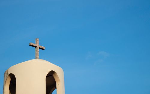 Free Minimalist image of a church tower with a cross against a clear blue sky in Bragança, Brazil. Stock Photo