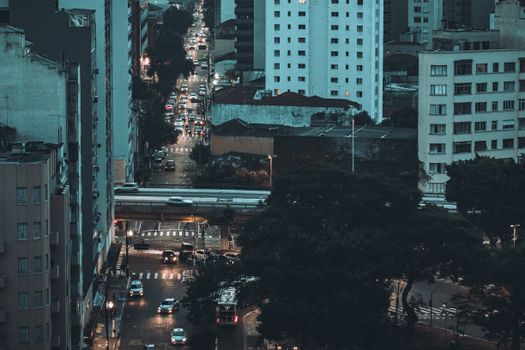 Aerial view of São Paulo city streets with illuminated buildings and traffic at dusk.