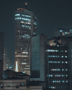 A night cityscape capturing São Paulo's modern skyline with the famous Copan Building illuminated.