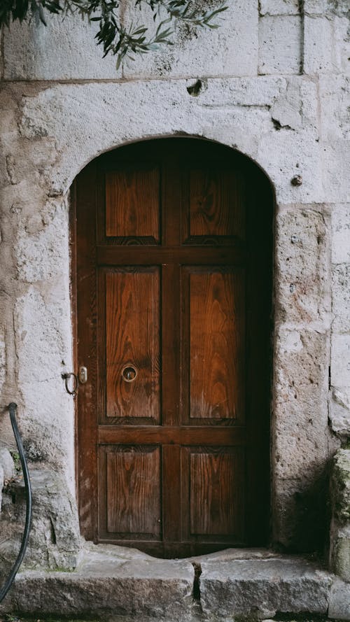 A wooden door with a stone wall in front of it