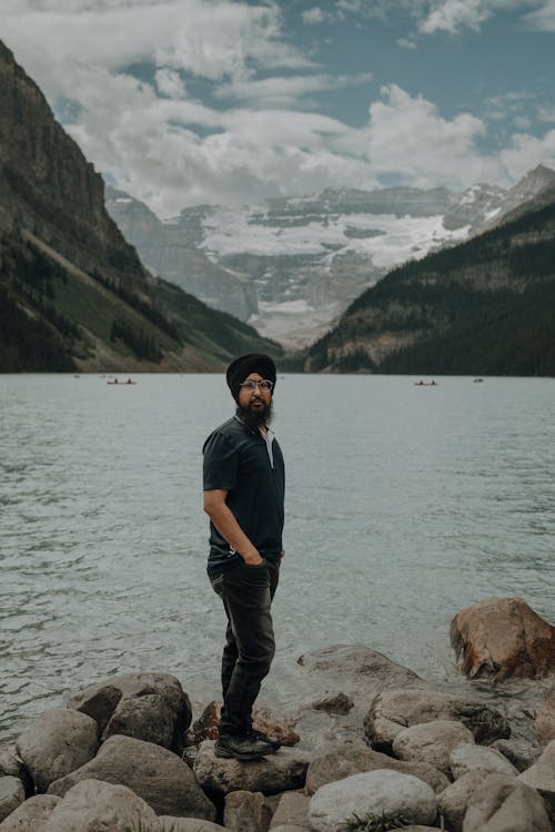 A man standing on rocks near a lake