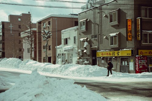 A person walking down a street in the snow