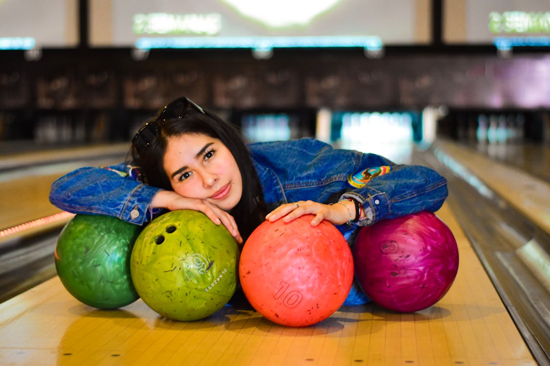 Woman Lying on Bowling Balls