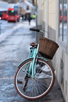 Charming vintage bicycle with a basket, parked on a snowy street in Jönköping, Sweden.