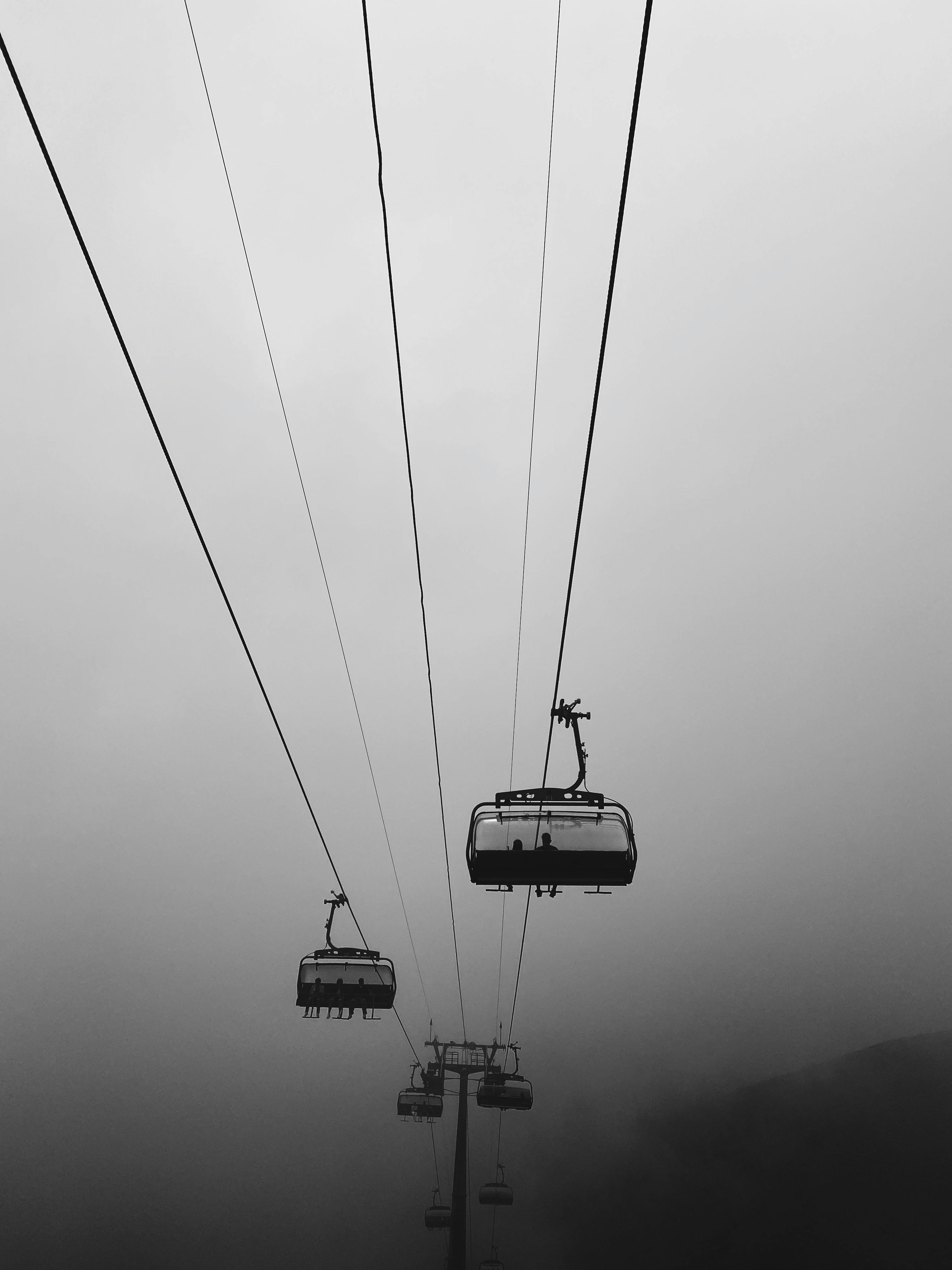 Black and white view of cable cars in foggy Sochi, Russia landscape.