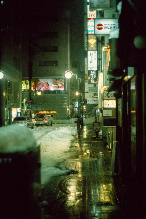 A street in tokyo at night with snow on the ground