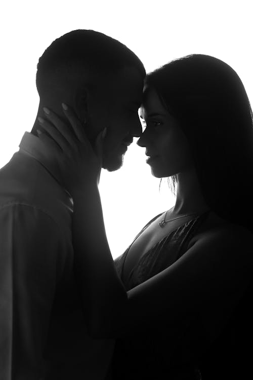 A silhouette of a man and woman kissing